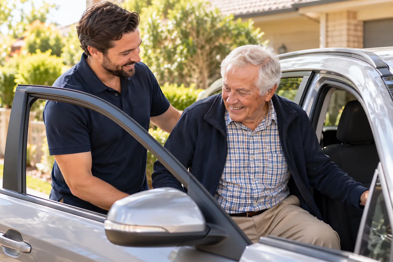 Support worker helping an older man into the passenger seat of a car